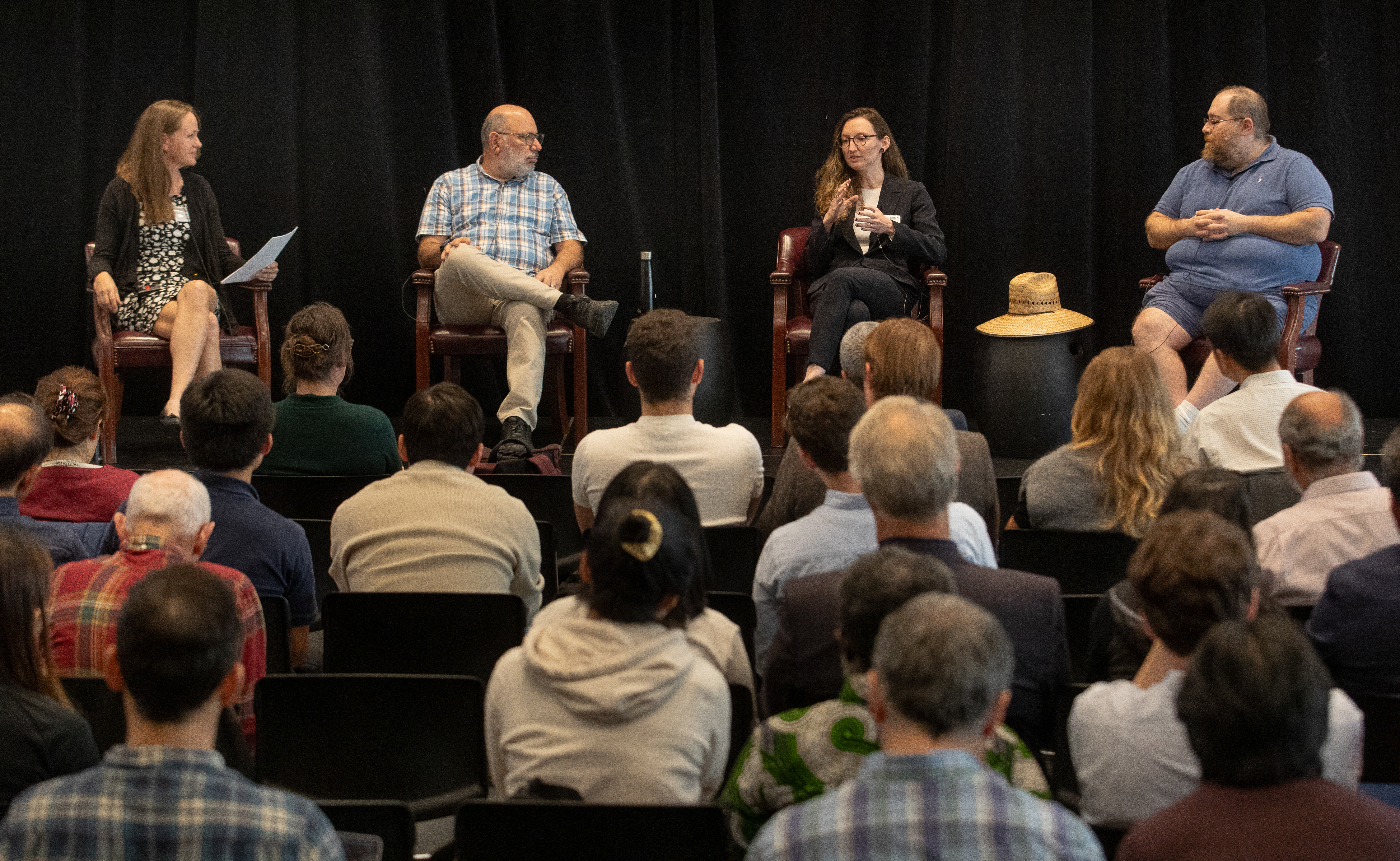 Photograph of fireside chat speakers in front of an audience at the 2024 Brains & Machines Symposium