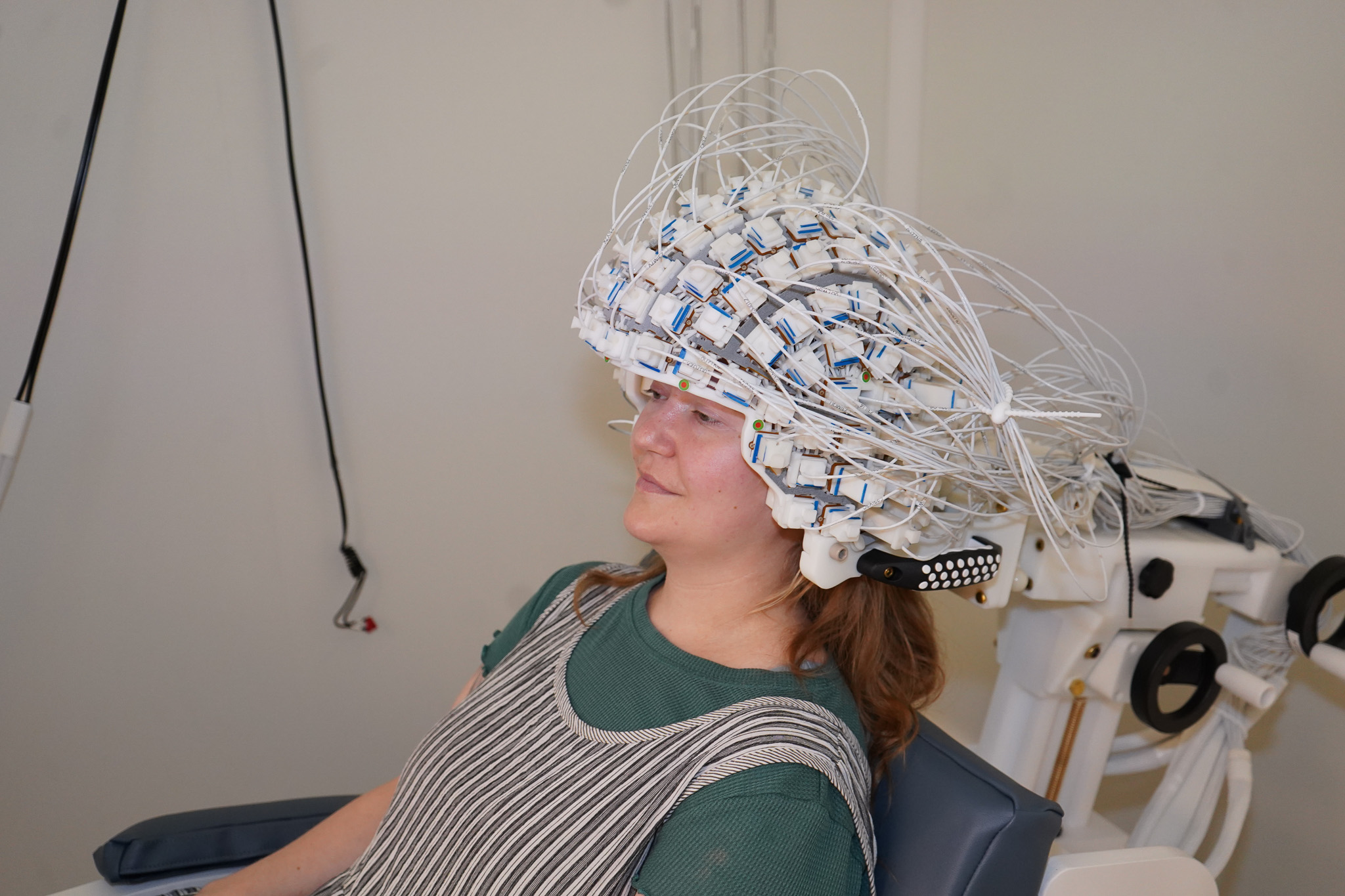 Inside the magnetically shielded room a participant wears the OPM-MEG helmet and sensor array