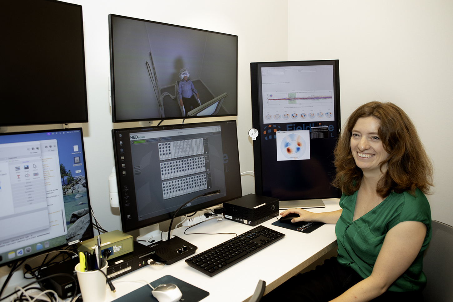 Milena Kaestner sits in front of a bank of computer monitors.