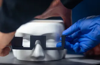 image of a person with gloves putting on holographic glasses on a figure