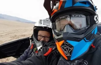 In this 2019 photo, Timothy syndrome patient Holden Hulet, left, rides in a side-by-side ATV driven by his dad, Kelby Hulet, at sand dunes near their home in southern Utah. 