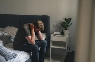 Man on bed looks depressed - Getty Imagesa