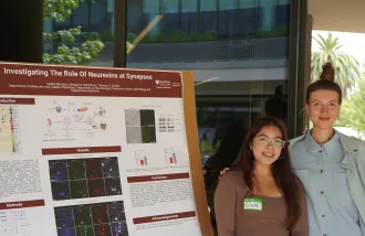 NeURO-CC Fellow Giselle Mendoza stands beside her summer research poster from the Thomas Sudhof Lab with her mentor, Margarita Artiukhova. 