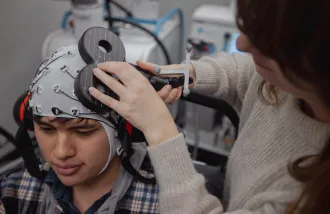 Milena Kaestner simultaneously records EEG and TMS brain stimulation in the Koret Human Neurosciences Community Laboratory at the Wu Tsai Neurosciences Institute.