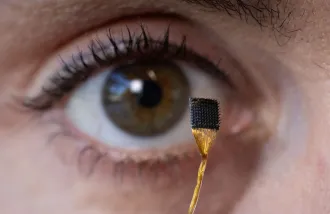 A close up of someone holding a microchip up to their eye
