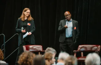 Julia Kaltschmidt and Todd Coleman speak before an audience.