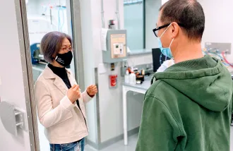 Jieun Kim discusses MRI imaging with a symposium attendee