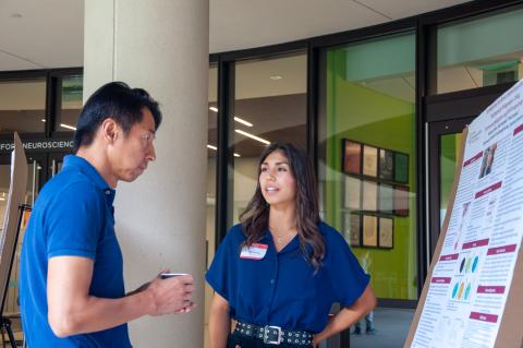 Maclaira Camper, NeURO fellow, discusses her research with Kang Shen, Vincent V.C. Woo Director of Wu Tsai Neuro, at the 2023 NeURO and NeURO-CC poster session. Photo by Victoria Hernandez.