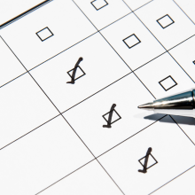 Image of a pen checking off boxes