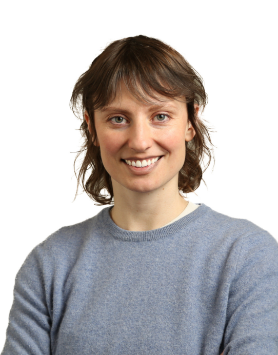 Dr. Laura Driscoll, wearing a grey sweater, smiles at the camera in front of a white background.