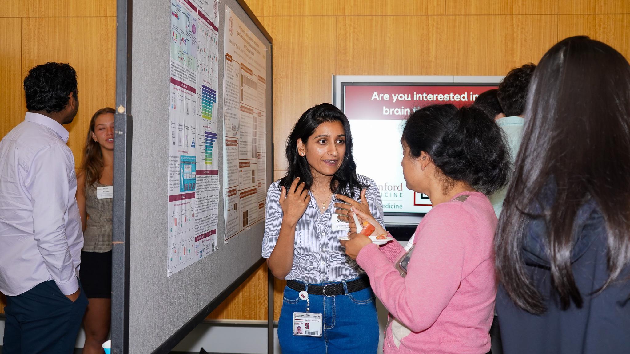 Marwa Zafarullah talks about her research poster with another person.