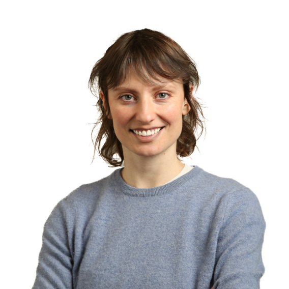 Dr. Laura Driscoll, wearing a grey sweater, smiles at the camera in front of a white background.