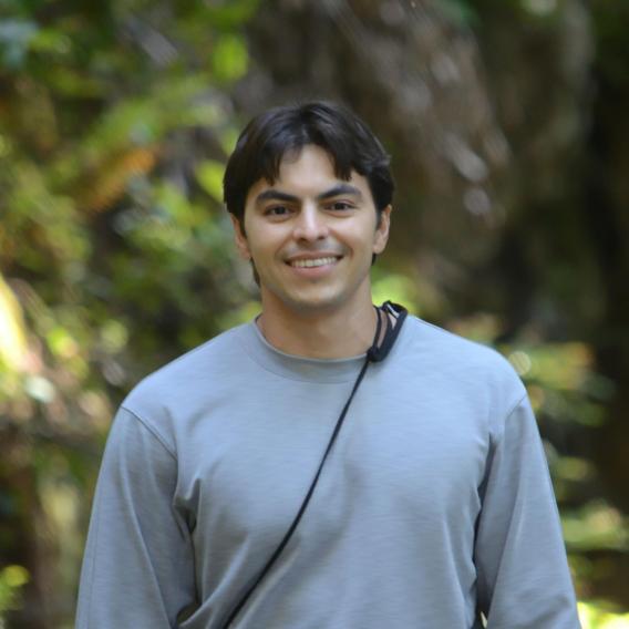 Picture of Alex Durango. He's wearing a grey t-shirt and looking directly at the camera smiling. 