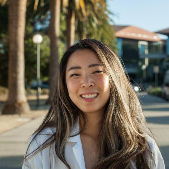 Image of Liz Jun standing outside of the Stanford Neurosciences Institute